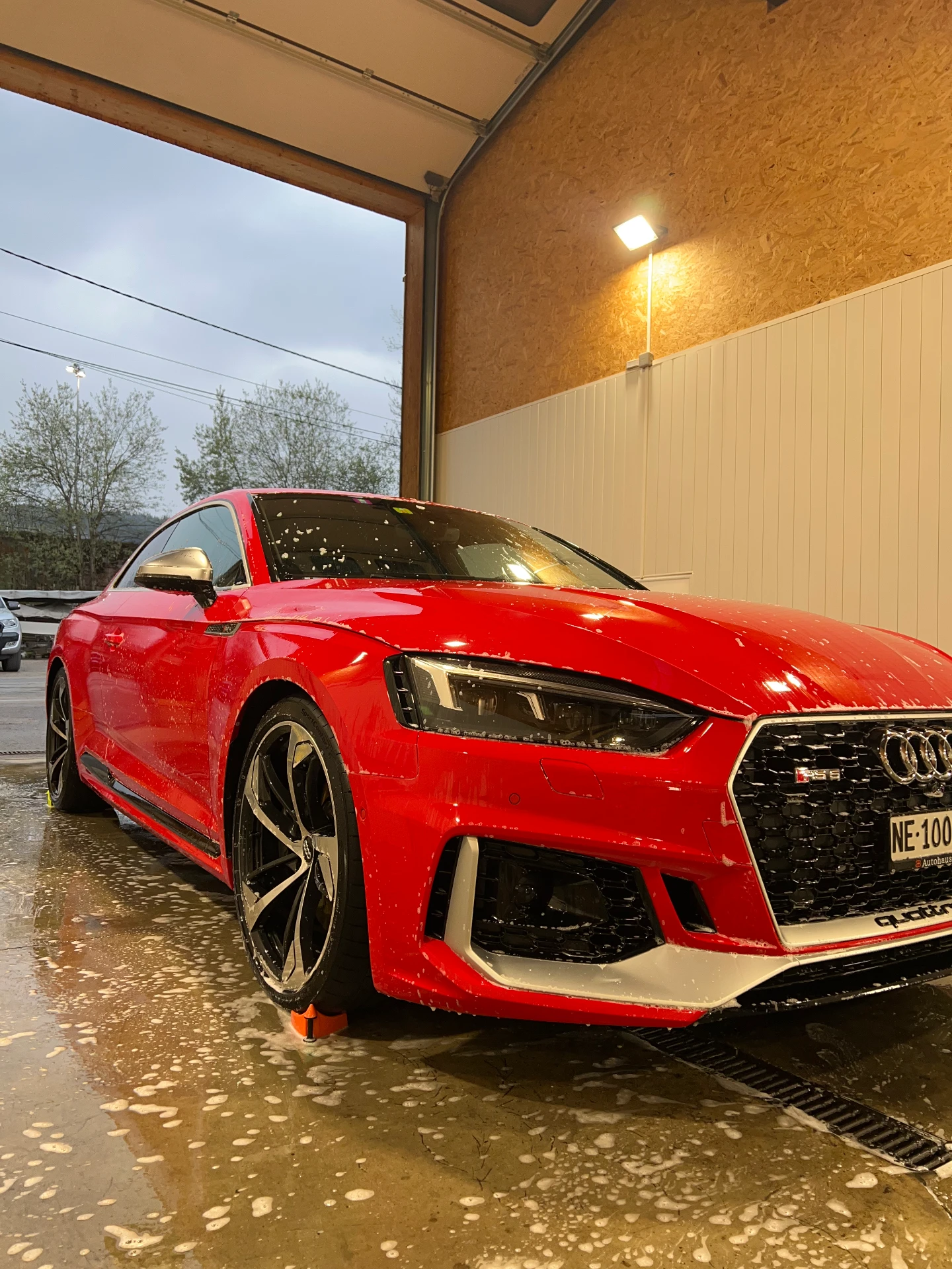 Audi RS5 rouge en cours de lavage dans l'atelier DCM Morteau